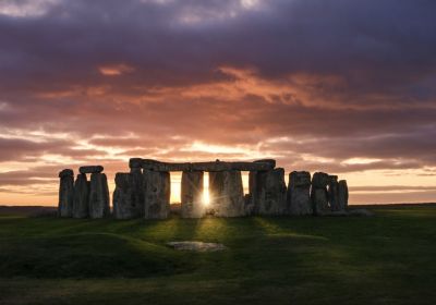 Stonehenge all'alba, con il sole che sorge dietro le pietre millenarie.