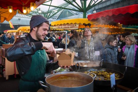 Al Borough Market banchi colorati di cibi caldi e street food invitano i visitatori a godersi un'esperienza culinaria unica e gustosa